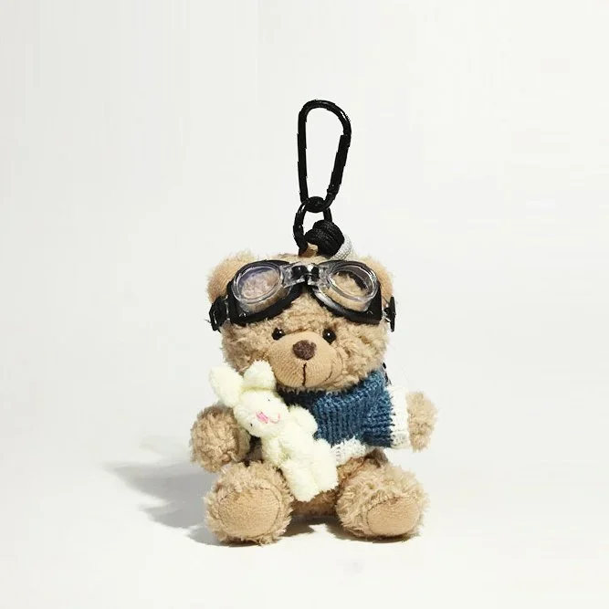 Bijou de sac aviateur en peluche tenant un lapin